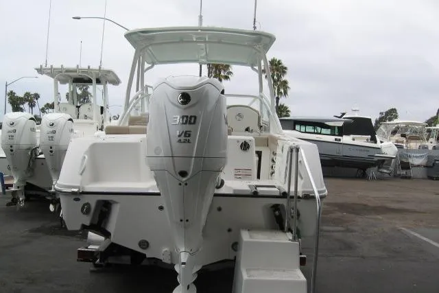 Slide: The Image of 2024 Edgewater 248CX Crossover boat with powerful outboard engine, docked at marina. - 10