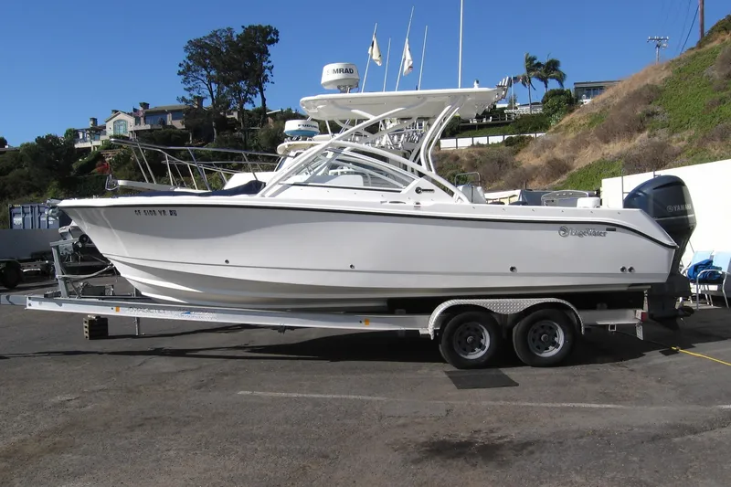 Slide: The Image of 2024 Edgewater 248CX Crossover boat on trailer, parked outdoors. - 22