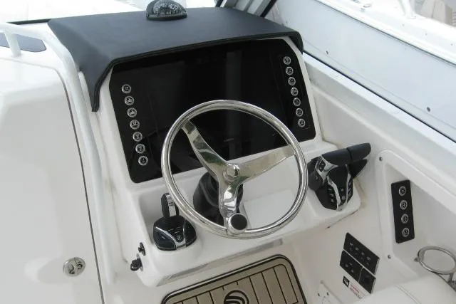 Slide: The Image of 2024 Edgewater 248CX Crossover boat dashboard with steering wheel and controls. - 5