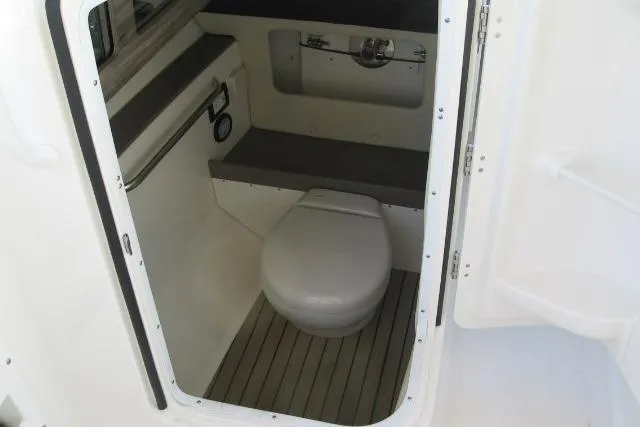 Slide: The Image of 2024 Edgewater 248CX Crossover boat interior with compact marine toilet. - 14