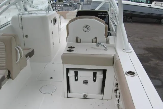 Slide: The Image of 2024 Edgewater 248CX Crossover boat interior with seating, sink, and cooler. - 8