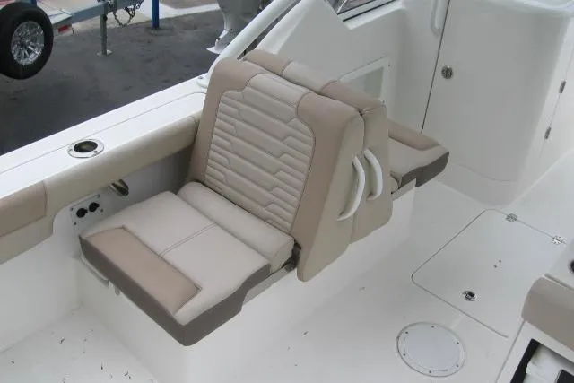 Slide: The Image of 2024 Edgewater 248CX Crossover boat interior with beige seating and cup holder. - 9