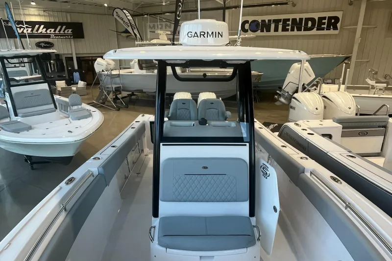 Slide: The Image of 2026 Sportsman Open 252 Center Console boat in showroom, featuring Garmin electronics. - 2