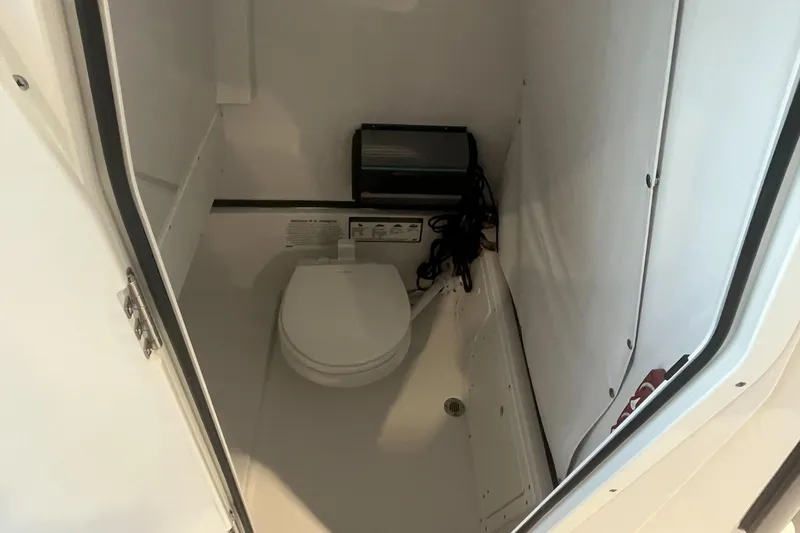 Slide: The Image of 2026 Sportsman Open 252 Center Console boat interior with compact marine toilet. - 7