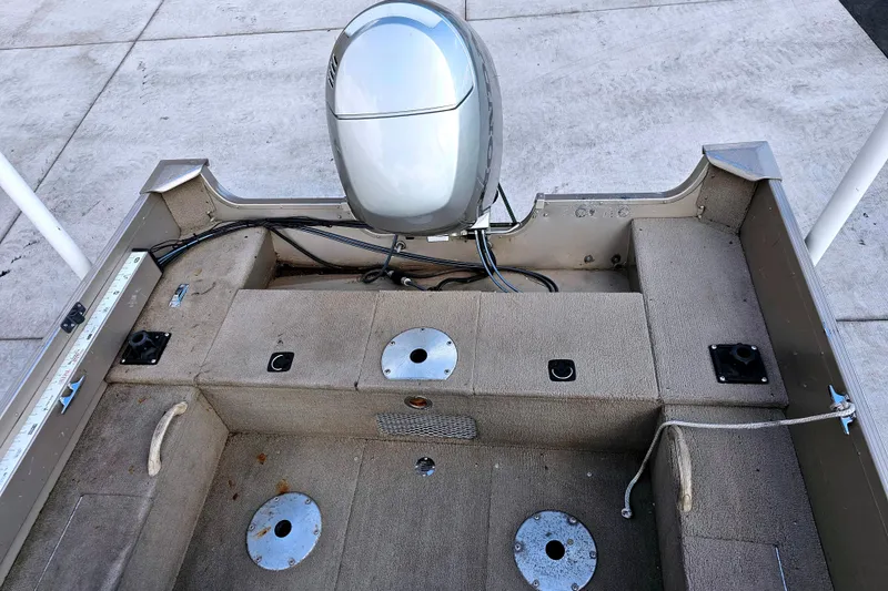 Slide: The Image of 2000 Alumacraft Navigator 165 CS boat interior with motor and seating area. - 11