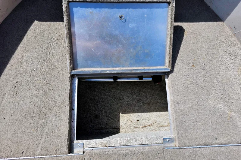 Slide: The Image of Open storage compartment on 2000 Alumacraft Navigator 165 CS boat deck. - 22