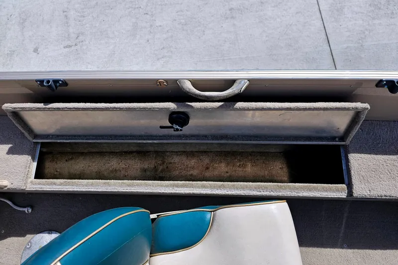 Slide: The Image of Open storage compartment in 2000 Alumacraft Navigator 165 CS boat, with blue and white seat. - 23