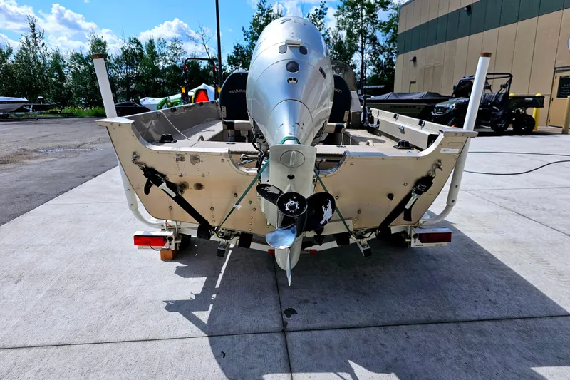 Slide: The Image of 2000 Alumacraft Navigator 165 CS boat with outboard motor, parked outdoors on concrete. - 6