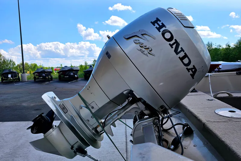 Slide: The Image of 2000 Alumacraft Navigator 165 CS with Honda four-stroke outboard motor in parking lot. - 7