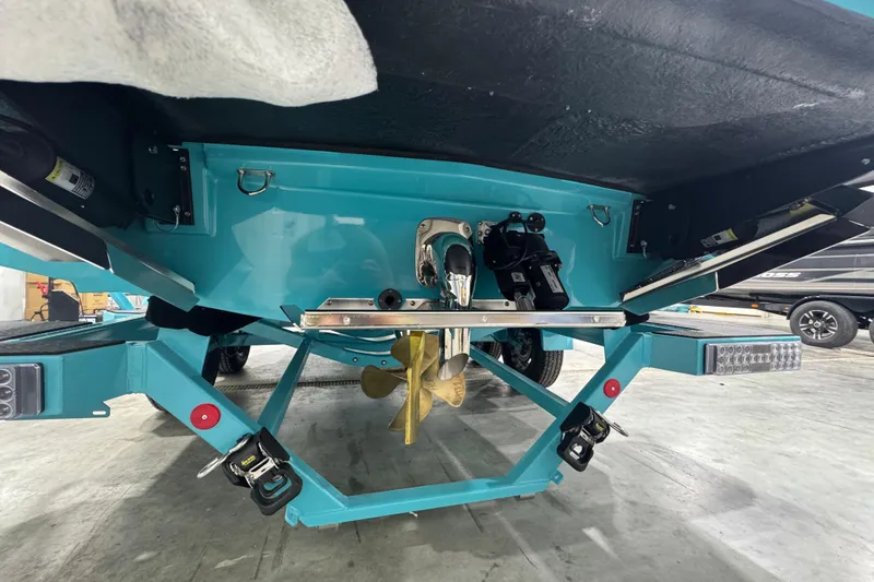 Slide: The Image of 2026 MasterCraft NXT22 boat underside with propeller and trailer in a garage. - 15
