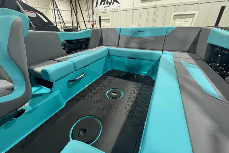 Slide: The Image of Interior of 2026 MasterCraft NXT22 boat with teal and gray seating. - 9