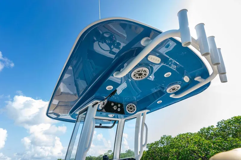 Slide: The Image of Manufacturer Provided Image: 2025 Sportsman Heritage 261 Center Console boat with blue T-top and speakers. - 12