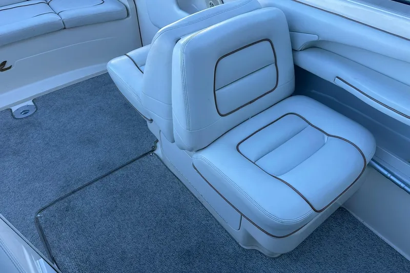 Slide: The Image of 1998 Sea Ray 280 Cuddy Cabin interior with white cushioned seating and gray carpet. - 12