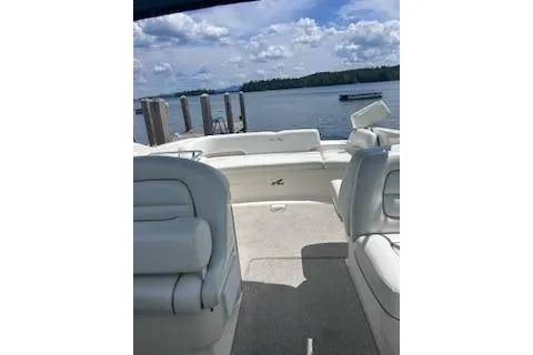 Slide: The Image of 1998 Sea Ray 280 Cuddy Cabin boat interior with white seating, docked by a serene lake. - 6