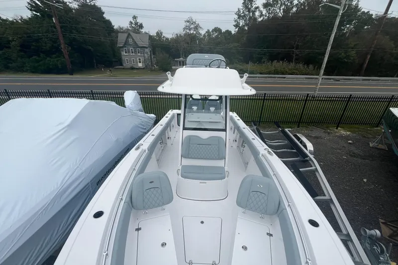 Slide: The Image of 2026 Sportsman Open 262 Center Console boat, parked outdoors, showcasing sleek design and seating. - 3