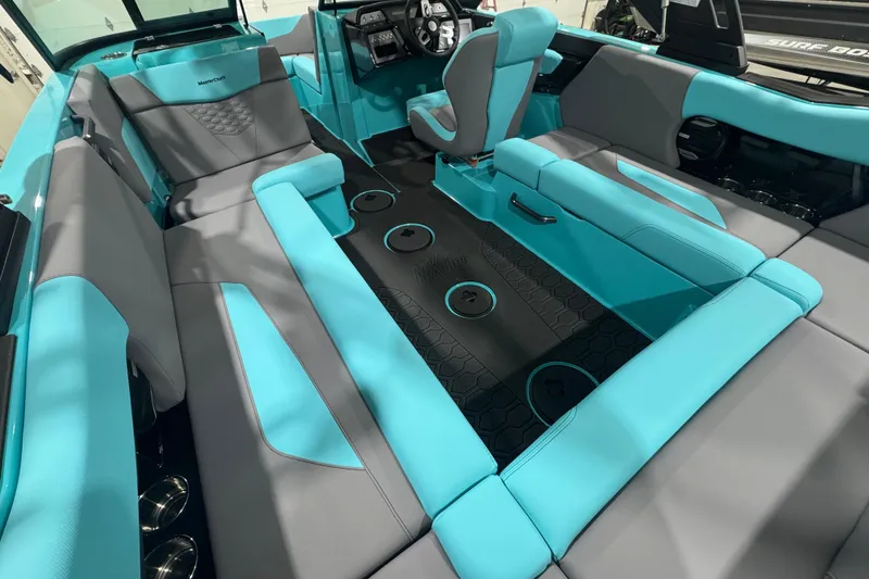 Slide: The Image of 2026 MasterCraft NXT22 interior with turquoise and gray seating, modern dashboard, and spacious layout. - 12