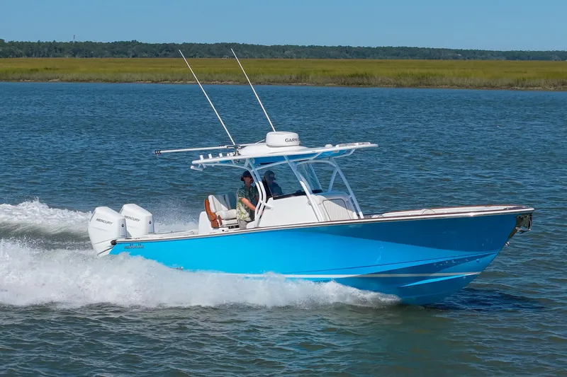 Slide: The Image of 2024 Valhalla Boatworks V-33 cruising on water, featuring sleek blue design and twin Mercury engines. - 45