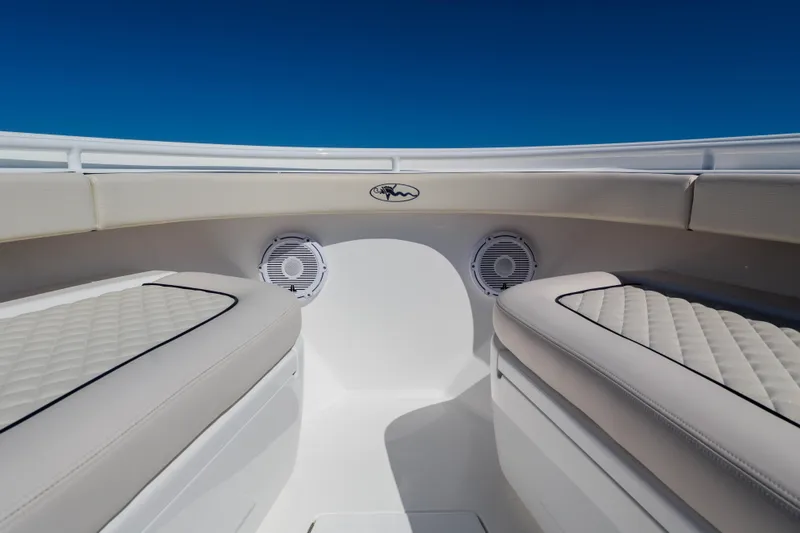 Slide: The Image of 2024 Valhalla Boatworks V-33 interior with cushioned seating and speakers under clear blue sky. - 7