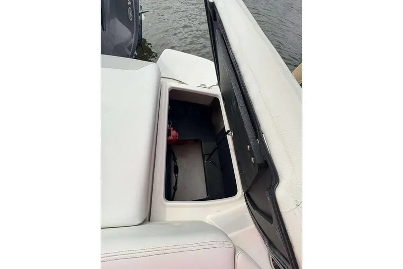 Slide: The Image of Open storage compartment on a 2018 Regal 21 OBX boat by the water. - 19
