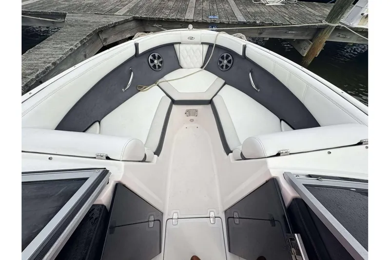 Slide: The Image of 2018 Regal 21 OBX boat interior with white seating and gray accents at dock. - 7