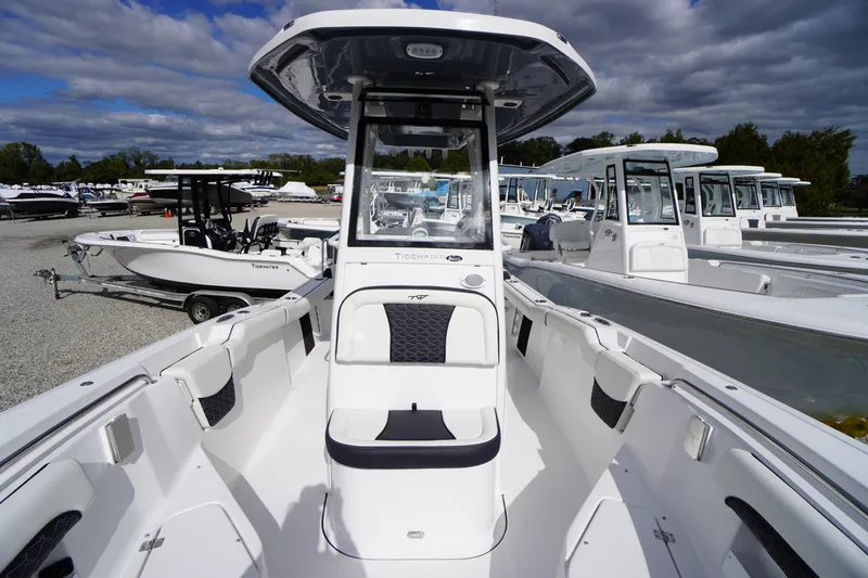 Slide: The Image of 2026 Tidewater 232 LXF boat with sleek design, docked among other boats. - 21