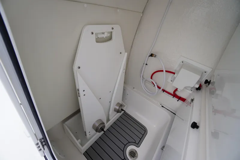 Slide: The Image of 2026 Tidewater 232 LXF boat interior with storage compartment and plumbing features. - 28