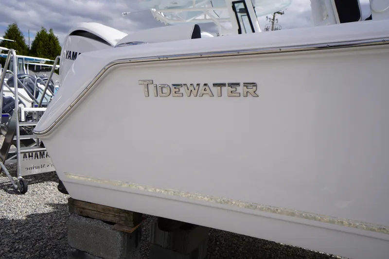 Slide: The Image of 2026 Tidewater 232 LXF boat side view with logo, parked outdoors. - 3