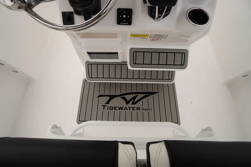 Slide: The Image of 2026 Tidewater 232 LXF boat interior with branded floor mat and steering console. - 34