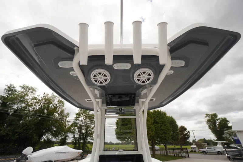 Slide: The Image of 2026 Tidewater 232 LXF boat with T-top speakers and rod holders, under cloudy sky. - 38