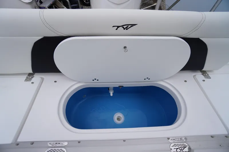 Slide: The Image of 2026 Tidewater 232 LXF boat livewell with open lid, showcasing blue interior. - 48