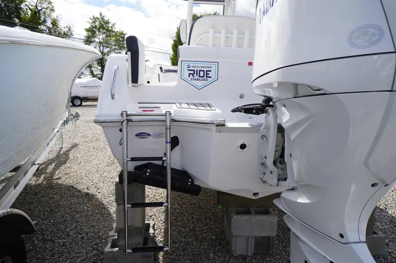 Slide: The Image of 2026 Tidewater 232 LXF boat with outboard motor and ladder, displayed on gravel. - 55