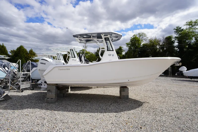 Slide: The Image of 2026 Tidewater 232 LXF boat displayed on gravel lot under cloudy sky. - 60