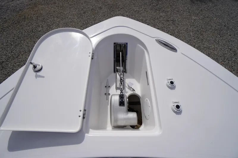 Slide: The Image of 2026 Tidewater 232 LXF boat anchor compartment with open hatch, showcasing chain and winch. - 8
