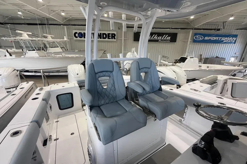 Slide: The Image of 2026 Sportsman Open 282 Center Console boat interior with dual seats in showroom. - 2