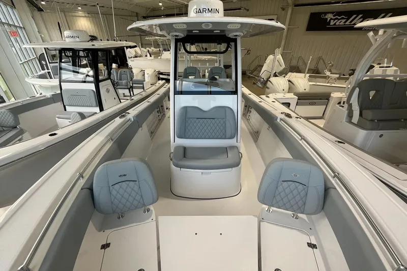 Slide: The Image of 2026 Sportsman Open 282 Center Console boat interior with gray seating in showroom. - 6