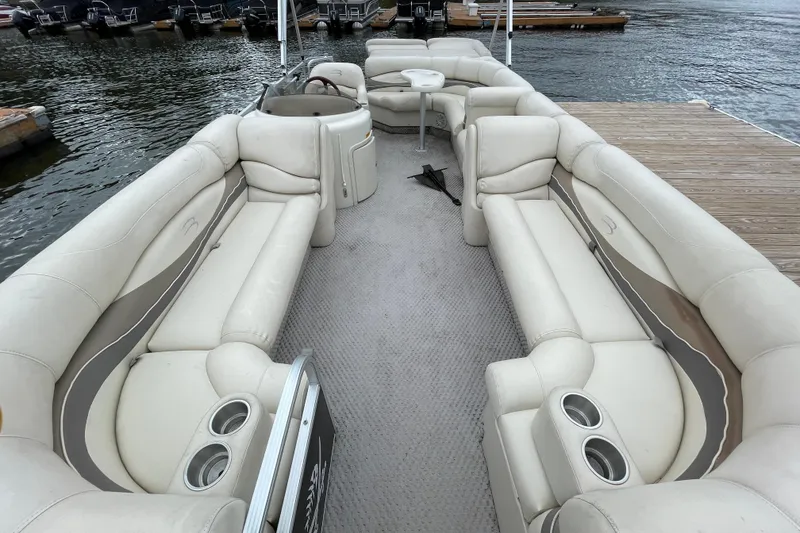 Slide: The Image of 2005 Bennington 2275RL pontoon boat with spacious seating, docked by the water. - 11
