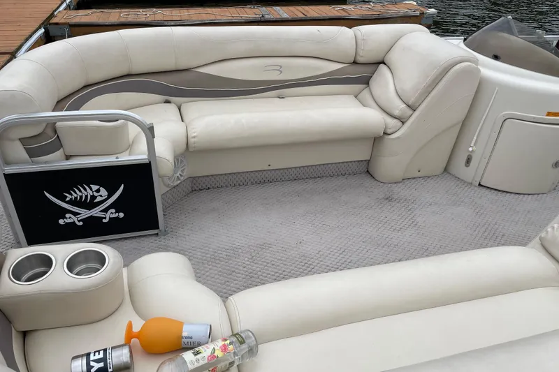 Slide: The Image of 2005 Bennington 2275RL boat interior with white seating and pirate-themed decor. - 3