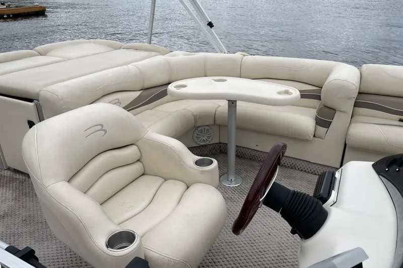 Slide: The Image of 2005 Bennington 2275RL pontoon boat interior with plush seating and steering wheel. - 5
