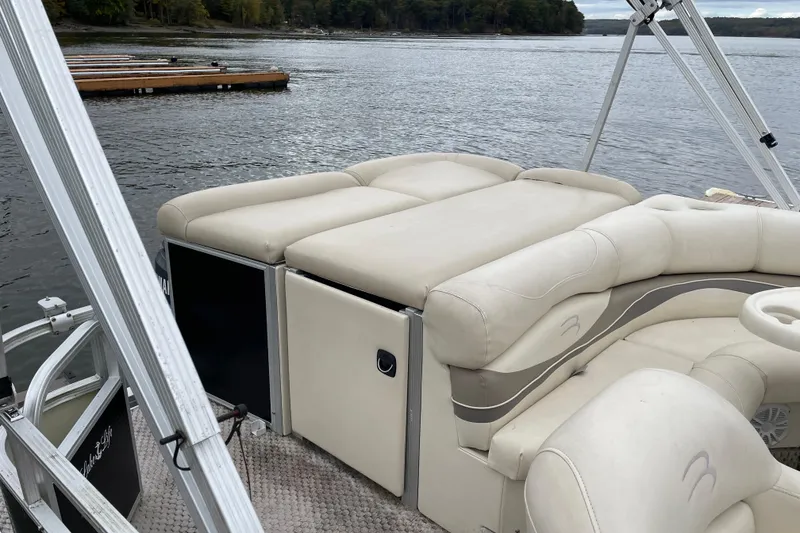 Slide: The Image of 2005 Bennington 2275RL pontoon boat with beige seating, docked on a calm lake. - 7