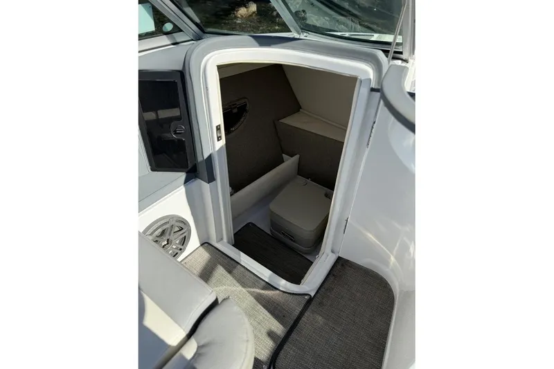 Slide: The Image of 2017 Cobalt 24SD boat interior cabin with compact toilet and carpeted flooring. - 14
