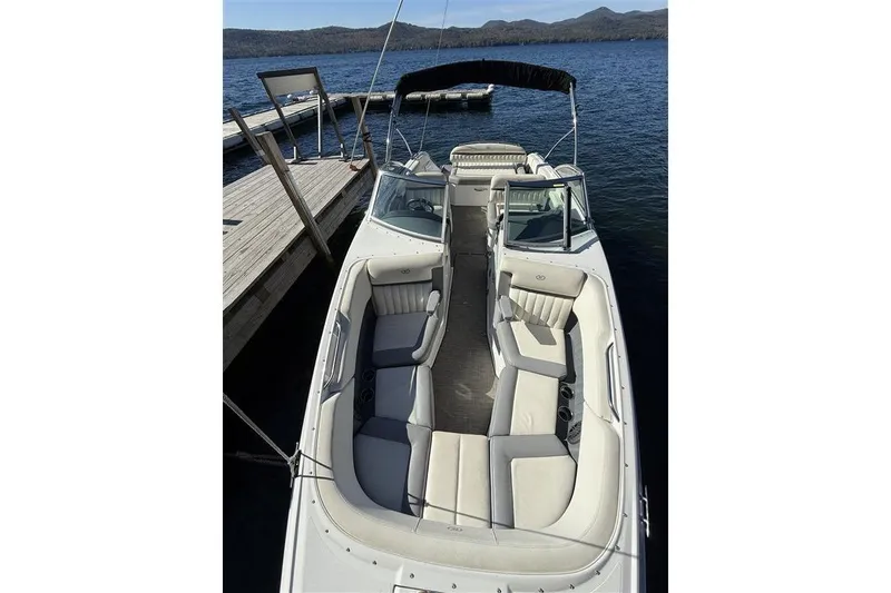 Slide: The Image of 2017 Cobalt 24SD boat docked on a serene lake with scenic mountain views. - 17