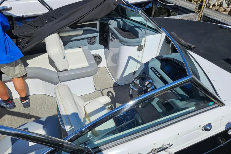 Slide: The Image of 2017 Cobalt 24SD boat interior with seating and steering wheel, docked at marina. - 22