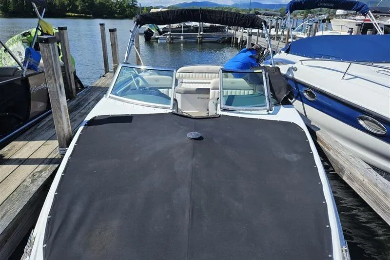 Slide: The Image of 2017 Cobalt 24SD boat docked with black cover, surrounded by other boats. - 25