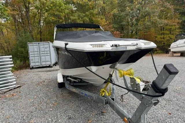 Slide: The Image of 2017 Cobalt 24SD boat on trailer, parked outdoors with autumn trees in background. - 36