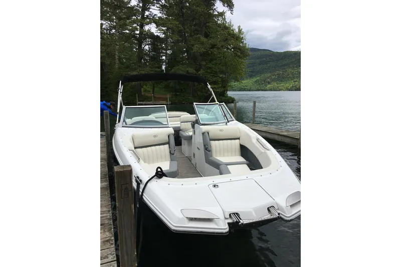 Slide: The Image of 2017 Cobalt 24SD boat docked by a scenic lake with lush greenery. - 4