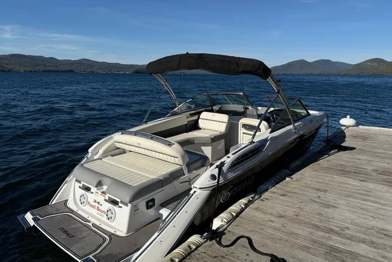 Slide: The Image of 2017 Cobalt 24SD boat docked on a scenic lake with mountains in the background. - 5