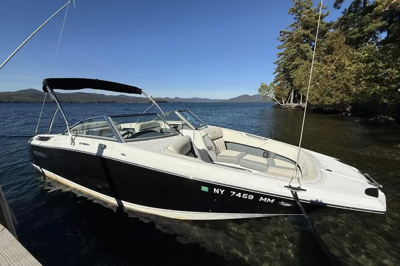 Slide: The Image of 2017 Cobalt 24SD boat docked on a serene lake with clear skies. - 7