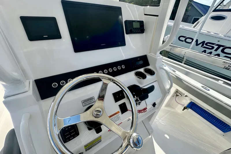 Slide: The Image of 2025 Regulator 23 boat dashboard with steering wheel and electronic displays. - 11