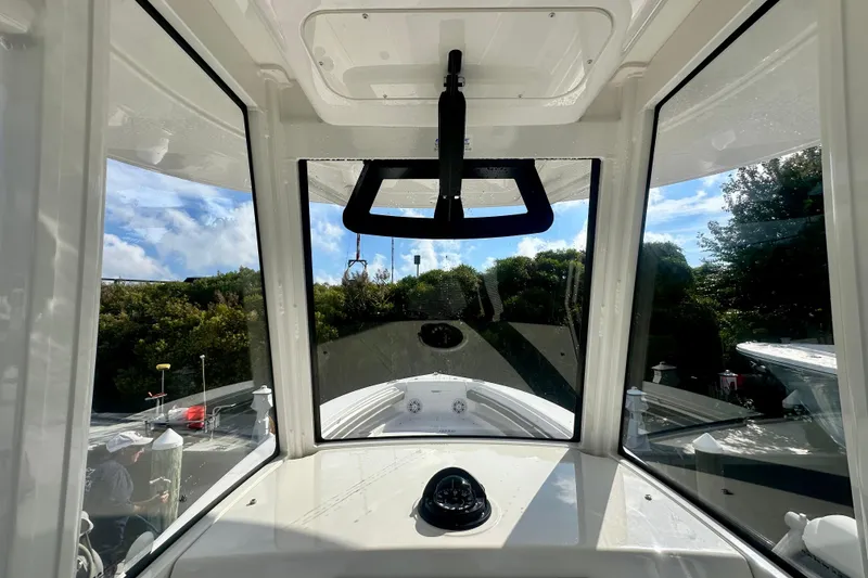 Slide: The Image of Interior view of 2025 Regulator 23 boat, showcasing helm and windshield. - 13