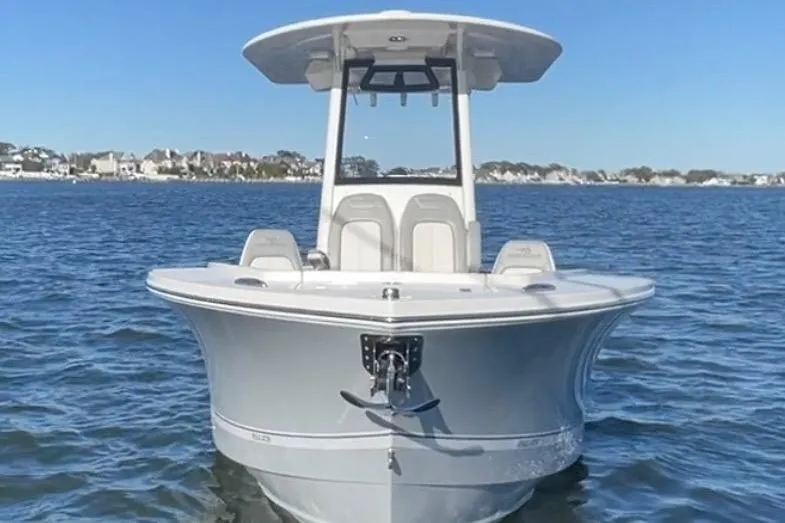 Slide: The Image of 2025 Regulator 23 boat on calm water, clear sky background. - 2